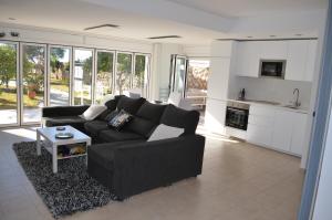 a living room with a black couch and a kitchen at Estrena loft en el mejor sitio de Tarragona in Tarragona
