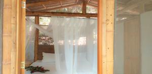 a room with a bed with a white curtain at Minca Glamping in Minca