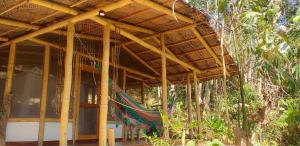 a building with a hammock under a wooden roof at Minca Glamping in Minca