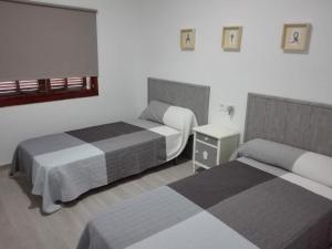 ein Hotelzimmer mit 2 Betten und einem Nachttisch in der Unterkunft Sa Cala Beach House in Cala Figuera