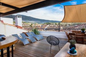 een balkon met stoelen en tafels en uitzicht bij La terrasse de Tiss in Bédoin