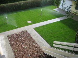 eine Luftansicht auf einen Garten mit einer Bank in der Unterkunft Kenese Gyöngye Apartmanház in Balatonkenese