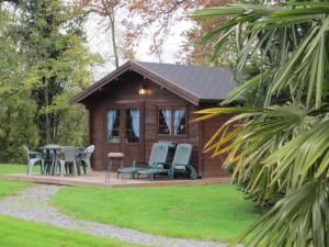 a small cabin with chairs and tables in a yard at CHALET GOYAVE in Épaignes