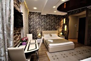 アドレルにあるStudio in Monaco Clubのベッド2台、テーブルと椅子が備わるホテルルームです。