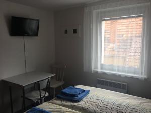 a bedroom with a bed and a desk and a window at Rodinný penzion in Mikulov