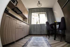 een keuken met een tafel en stoelen en een raam bij Tania Apartament in Oradea