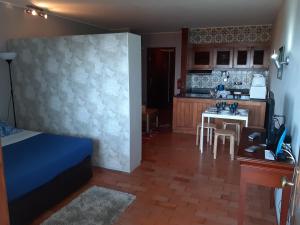 a room with a bed and a kitchen with a table at Apartamentos Matur in Machico