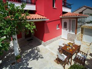 a patio with a table and chairs in front of a red building at Venezia Apartments in Sami