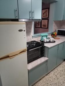 a kitchen with a refrigerator and a stove at Mets 3 mins away from Panathenaic (Kallimarmaro) Stadium in Athens