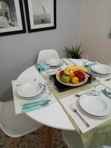 a white table with a plate of fruit on it at Mets 3 mins away from Panathenaic (Kallimarmaro) Stadium in Athens
