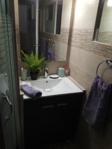 a bathroom with a white sink and a mirror at Mets 3 mins away from Panathenaic (Kallimarmaro) Stadium in Athens