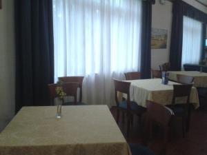 a dining room with tables and chairs with white curtains at Hotel Eden in Perdifumo