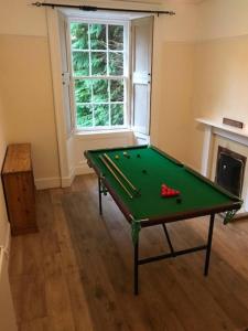 uma mesa de bilhar verde num quarto com lareira em Traditional Family Home in Royal Deeside em Aboyne
