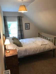 um quarto com uma cama e uma janela em Traditional Family Home in Royal Deeside em Aboyne
