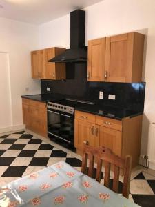 uma cozinha com armários de madeira e um forno com placa de fogão em Traditional Family Home in Royal Deeside em Aboyne