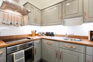 una cocina con armarios blancos y fregadero en The Jeffrey Street Retreat en Edimburgo