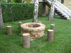 a fire pit in the middle of a yard with trees at Kenese Gyöngye Apartmanház in Balatonkenese