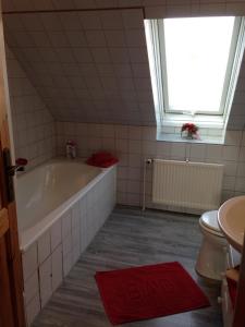 ein Badezimmer mit Badewanne und Toilette und einem Fenster in der Unterkunft Ferienwohnung 'Lydia' in Bornum + 7 Fotos