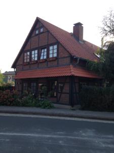 ein braunes Haus mit einem roten Dach auf einer Straße in der Unterkunft Ferienwohnung 'Lydia' in Bornum