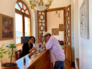 a man and a woman standing at a counter at Vista del Angel Hotel Boutique in Quito