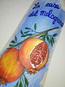 a painting of a pomegranate on a branch at La casa del melograno in Marsala