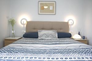 a bedroom with a bed with a blue and white blanket at Synergie SI09 - La Jota in Salou