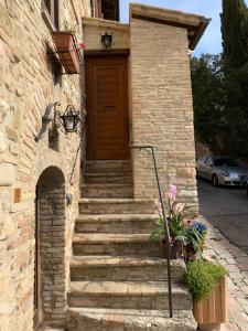 un edificio de ladrillo con escaleras que conducen a una puerta en La Torretta del Sementone, en Asís