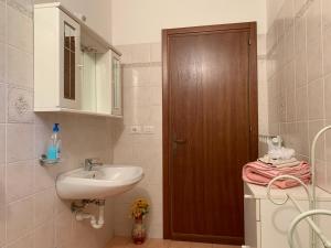 baño con lavabo y puerta de madera en La Torretta del Sementone, en Asís