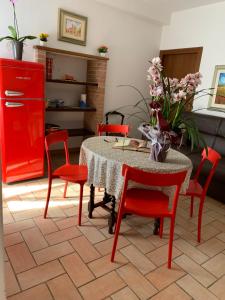 sala de estar con mesa y sillas rojas en La Torretta del Sementone, en Asís