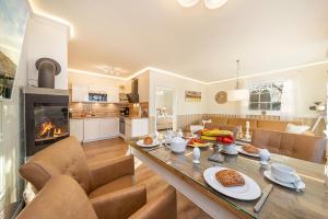 a kitchen and living room with a table and a fireplace at Villa Strandblick in Zingst