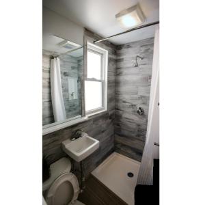 bagno con lavandino, servizi igienici e specchio di Boston Homestel a Boston