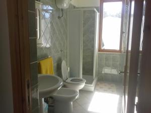 een badkamer met een toilet, een wastafel en een douche bij Villa Solinas in Sorso