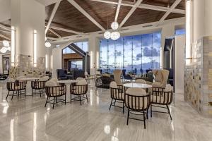 a lobby with tables and chairs and a large window at Royalton CHIC Cancun, An Autograph Collection All-Inclusive Resort - Adults Only in Canc&uacute;n