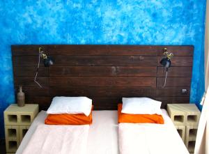 two beds in a room with a blue wall at Hedonist Lodge in Budapest