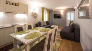 a kitchen and a living room with a table and a couch at Apartments Villa Jovovic in Budva