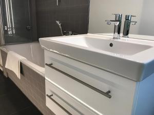 a bathroom with a white sink and a bath tub at Zentrum Apartment Bad Schandau in Bad Schandau