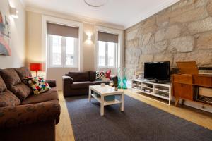 a living room with a couch and a tv at Fishtail Sea House in Matosinhos