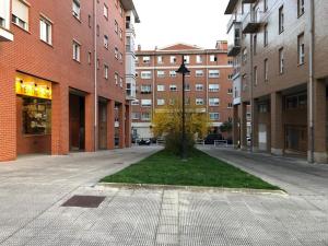 an empty street in a city with tall buildings at Apartamentos Villava Pamplona in Villava