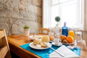 a wooden table with breakfast foods on it at Fishtail Sea House in Matosinhos +12 photos