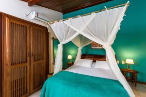 a bedroom with a bed with a canopy at Hotel Pousada Coqueiros in Arraial d'Ajuda