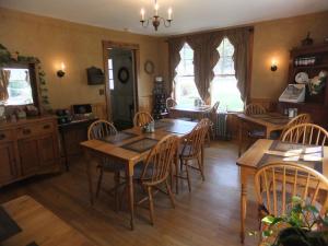 comedor con mesas y sillas de madera en Covered Bridge House, en Glen