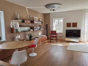 ein Wohnzimmer mit einem Tisch, Stühlen und einem TV in der Unterkunft Ferienwohnung Dausacker in Utting