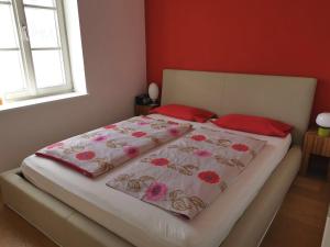 a bed in a bedroom with red walls and red pillows at Ferienwohnung Dausacker in Utting