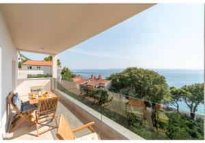 a balcony with a table and chairs and a view of the ocean at Apartments Mimac in Omiš