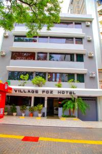 a building with a sign that reads village for hotel at Hotel Village Foz in Foz do Iguaçu