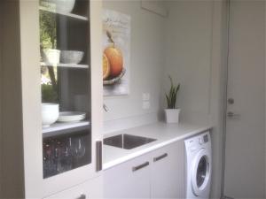 a kitchen with a sink and a washing machine at The Lakeview House in Taupo