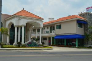 un bâtiment d'hôtel avec une arche et une rue dans l'établissement hotel villa magna poza rica, à Poza Rica de Hidalgo