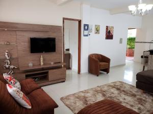sala de estar con TV de pantalla plana y sofá en Yolanda Family House en Foz do Iguaçu