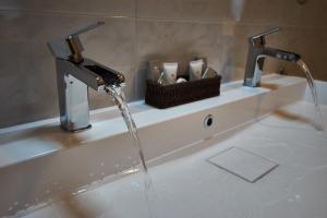 a bathroom sink with water running from a faucet at Villa Valentina in Cisternino +46 photos
