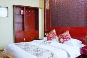 - une chambre avec un grand lit et une tête de lit en bois dans l'établissement Xing Xin Hotel, à Dunhuang